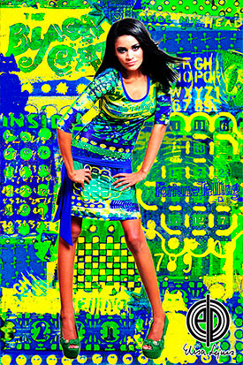 Model in kleurrijke outfit van Arubaanse kunstenares, met een op maat bewerkte achtergrond die naadloos aansluit op de kunstprint van de stof.